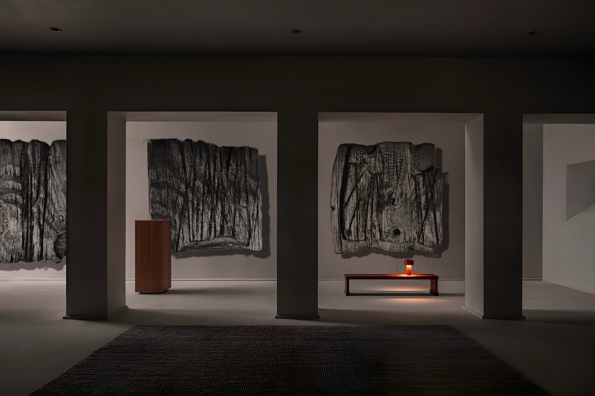 MORI — Charcoal Black, three large charred relief panels in a dark gallery interior