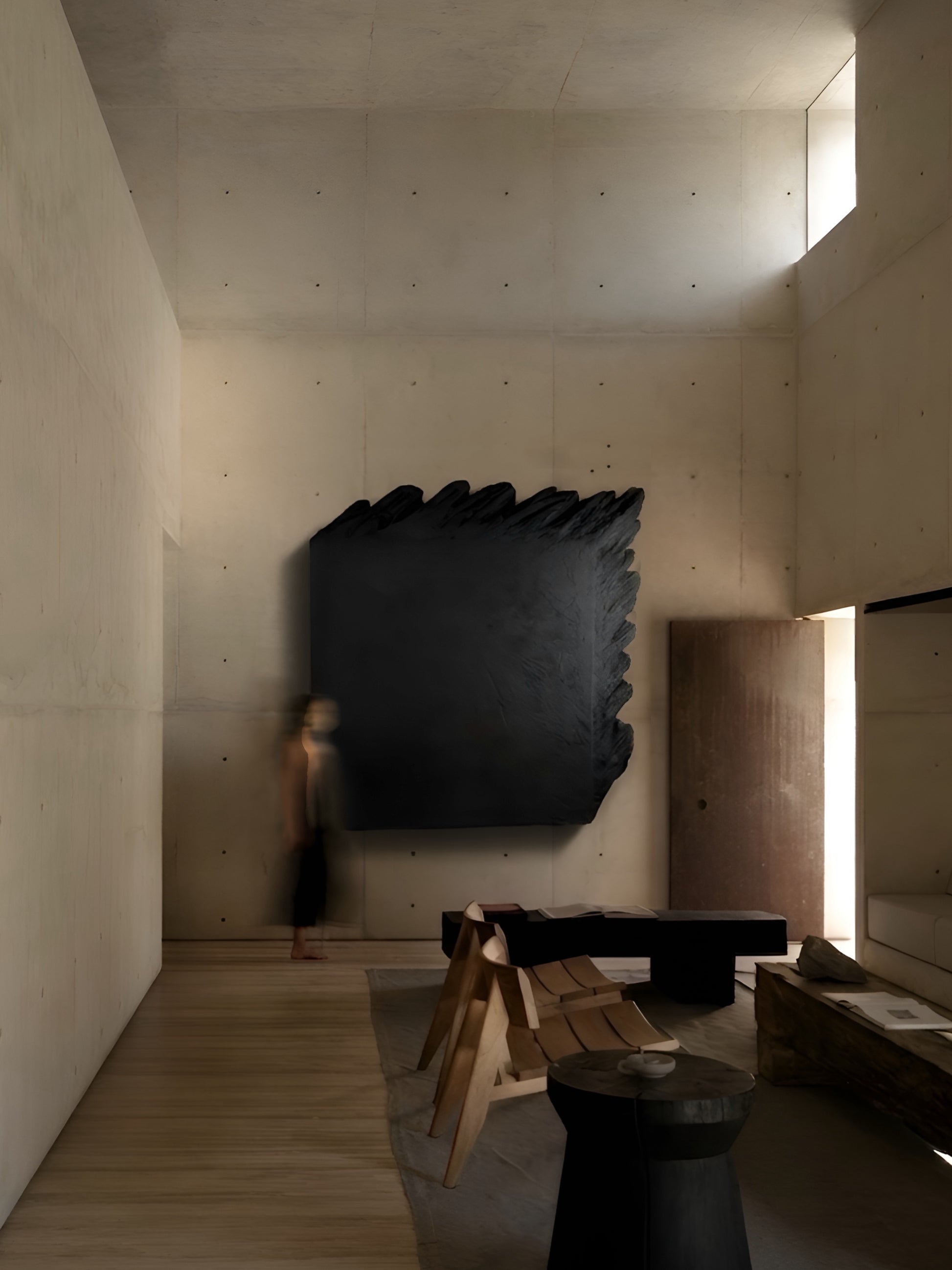 Modern interior with a large black abstract sculpture on a concrete wall.