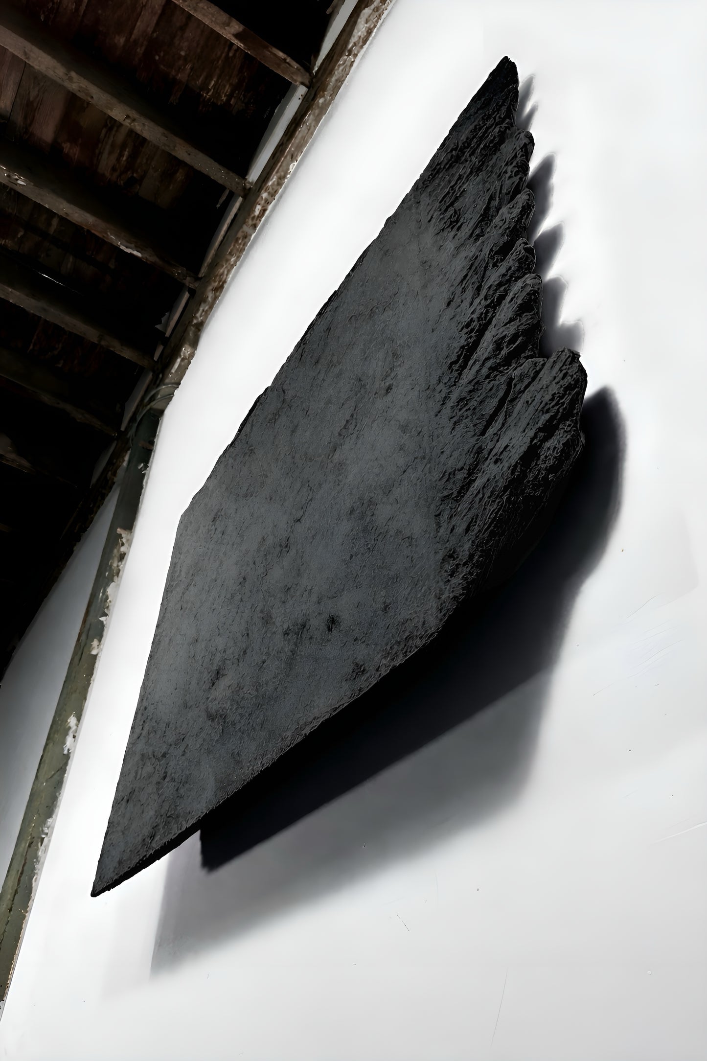 Large black stone on a white surface with a dark background