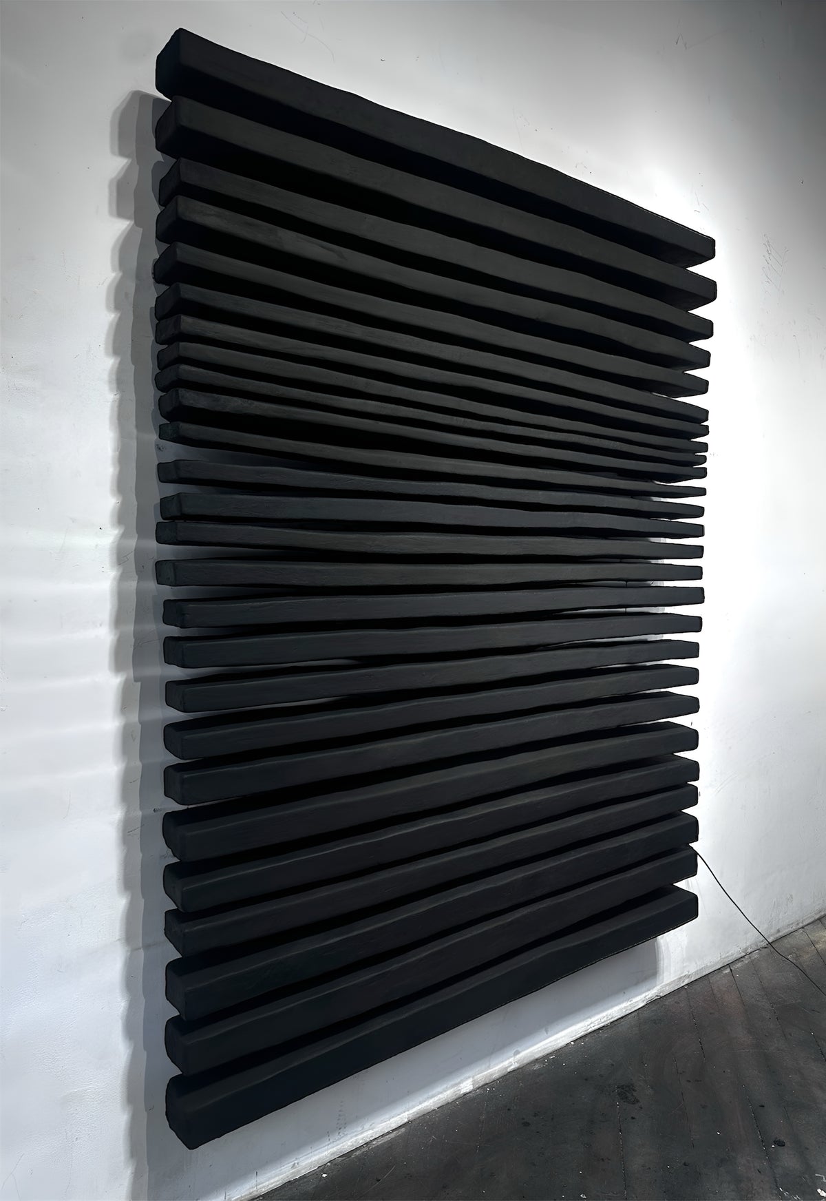 SHADOW — Noir Statement, full black ridged relief on white wall, angled view