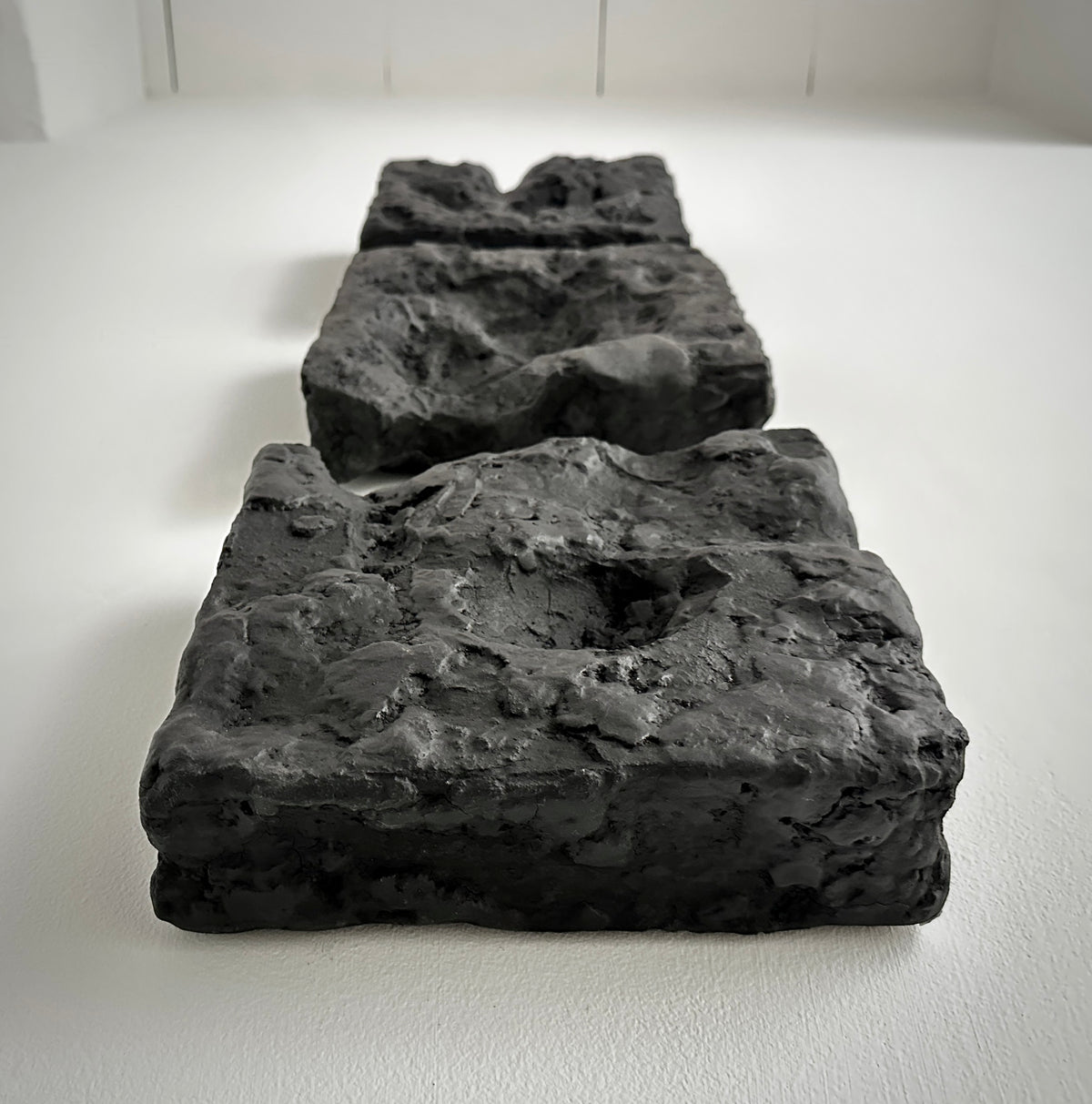 GAIA — Black Raw, wall installation view, black sculptural relief, raw textured surface