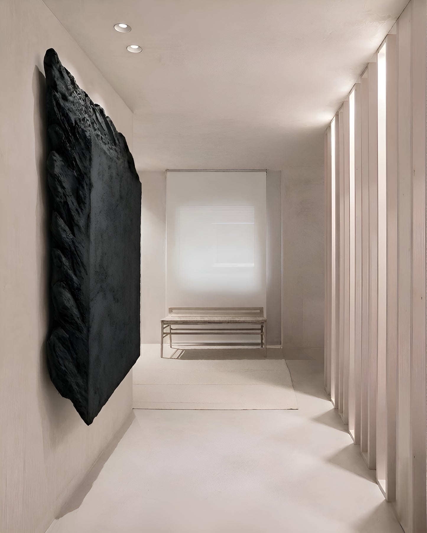 Modern interior hallway with a black abstract sculpture on the wall.