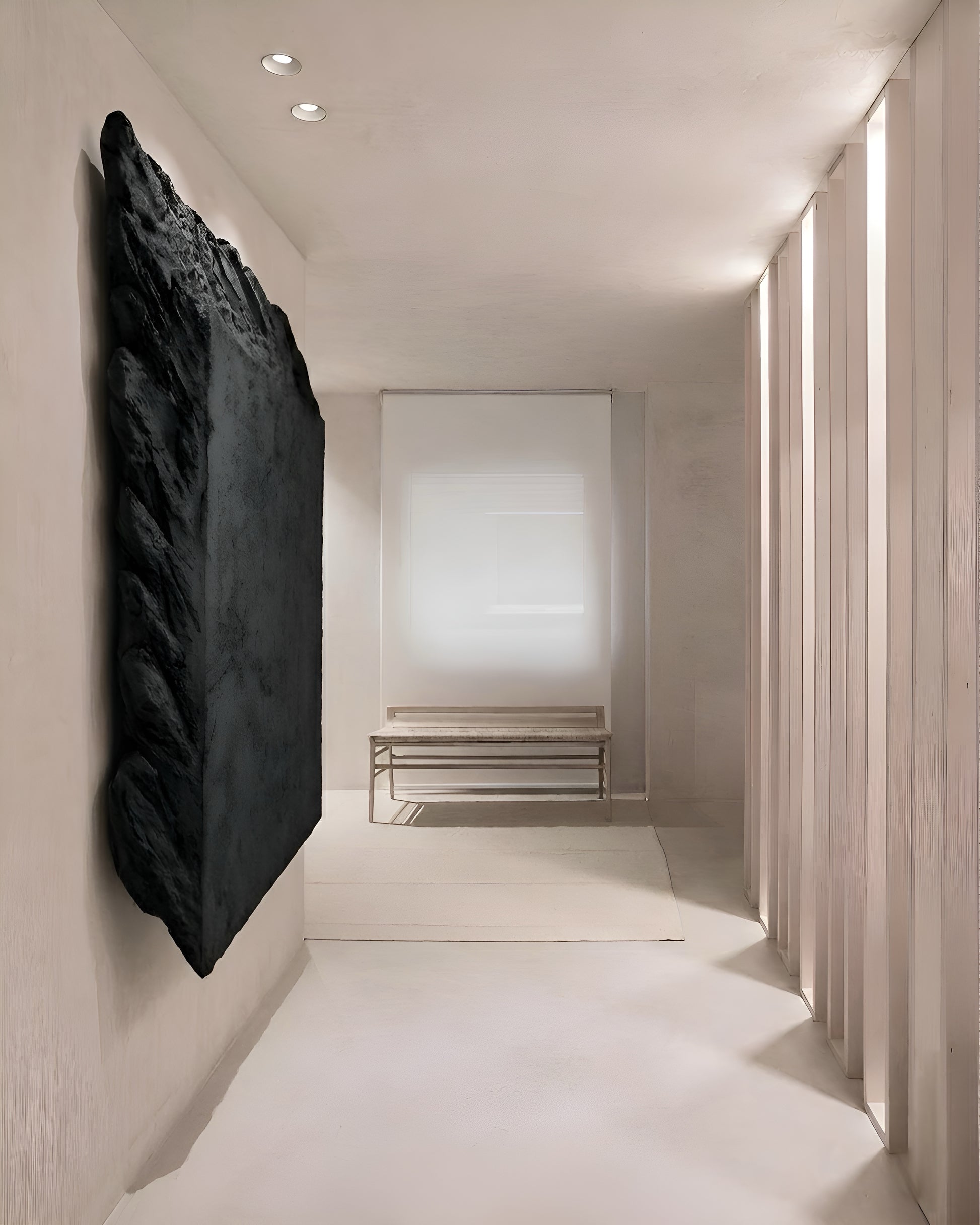 Modern interior hallway with a black abstract sculpture on the wall.