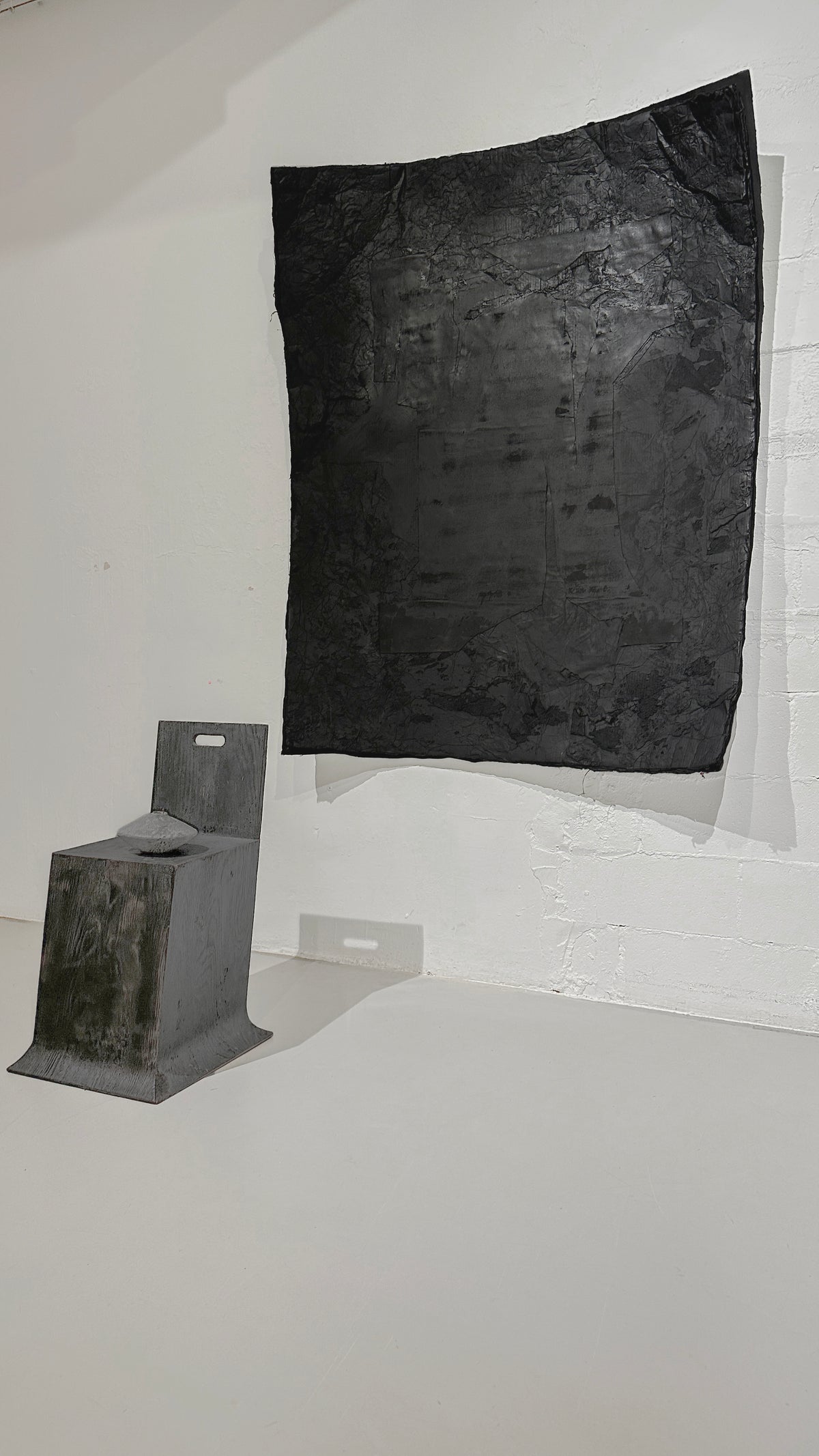 STRATA — Black, gallery view with pedestal for scale