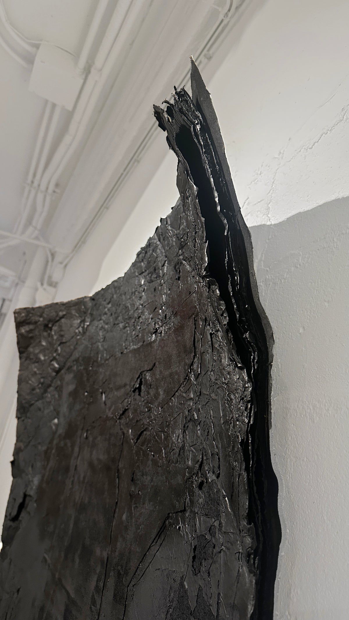 STRATA — Black, close-up of torn edge and layered black plaster surface