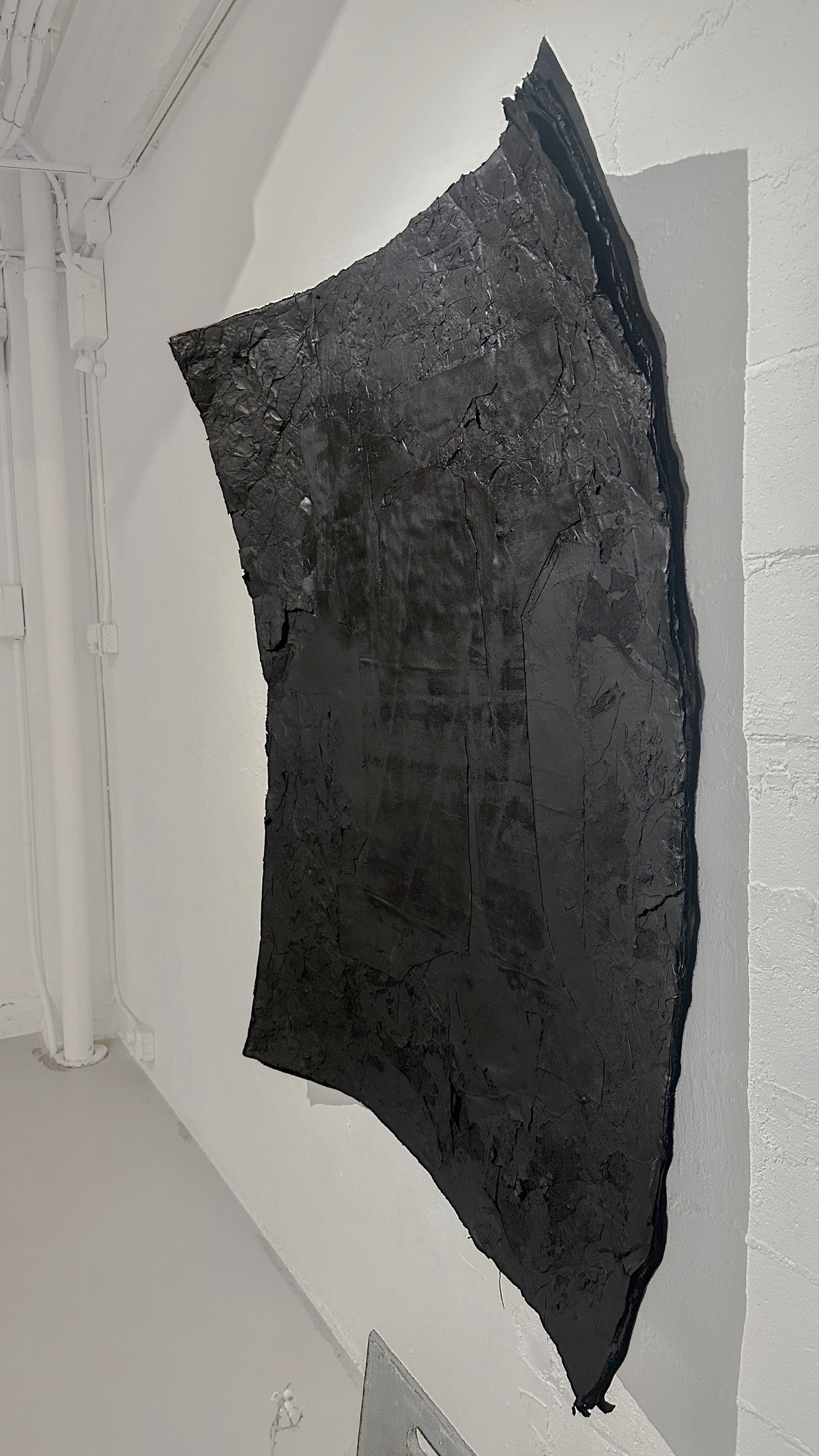 STRATA — Black, steep perspective, curving panel lifting from the wall