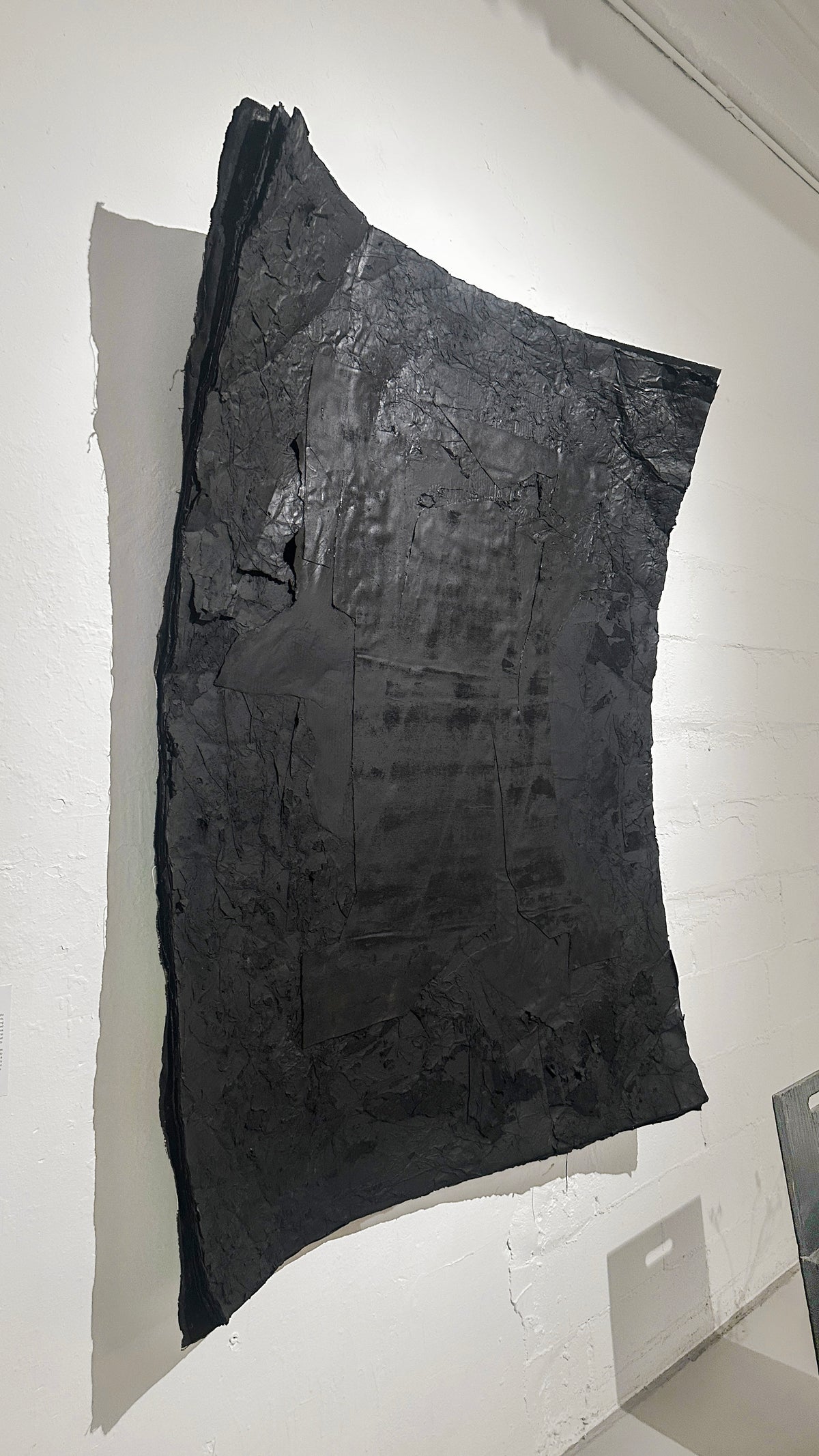 STRATA — Black, angled view showing curved edge and relief thickness
