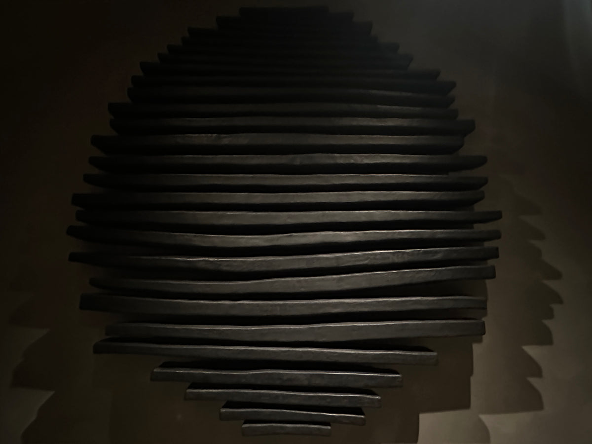 Detail of black projecting rods with raking light across the tips