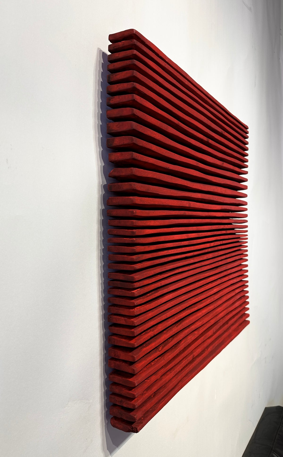 SHADOW — Crimson Study, steep side view, layered red ridges projecting from white wall