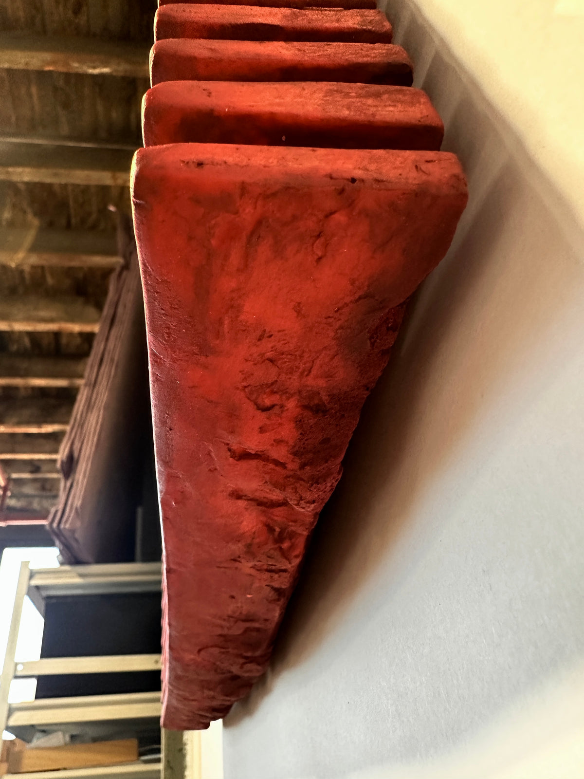 SHADOW — Crimson Study, top-down view of a ridge edge, rough hand-worked plaster surface