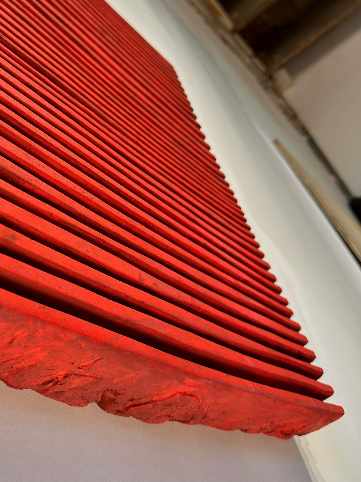 SHADOW — Crimson Study, raking light along red ridges, broken plaster edge in foreground