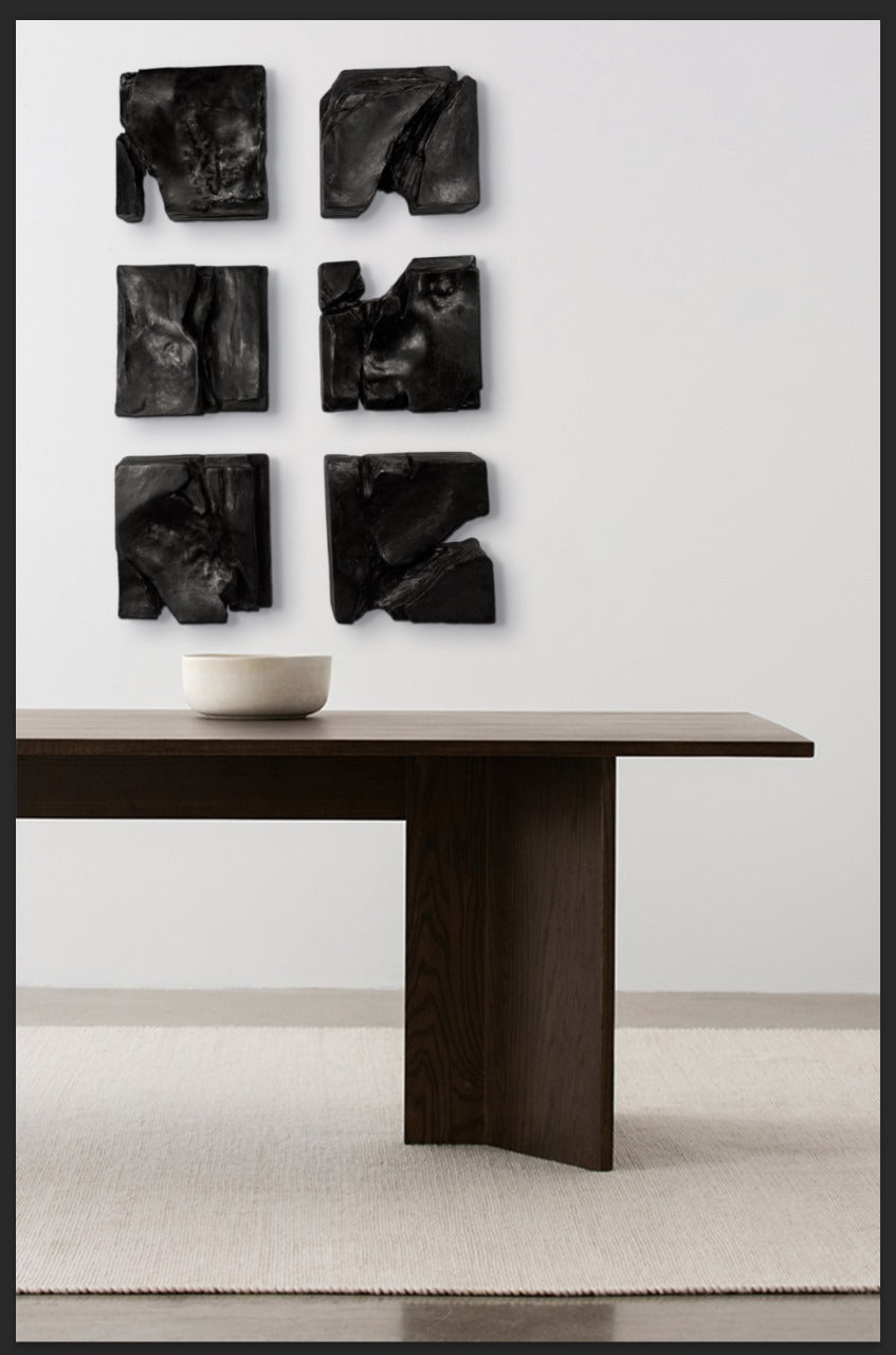 Dining room with a dark wooden table and abstract black wall art.