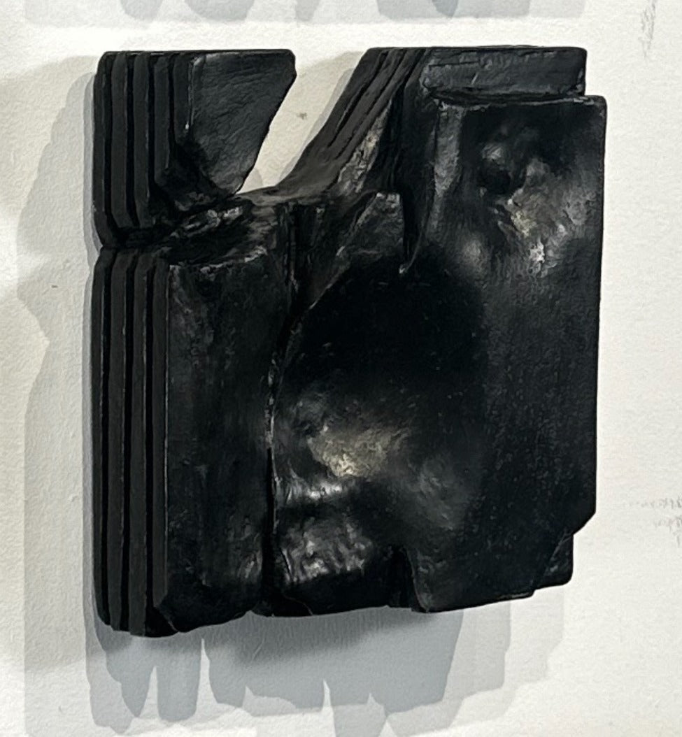 Black abstract sculpture on a textured white background