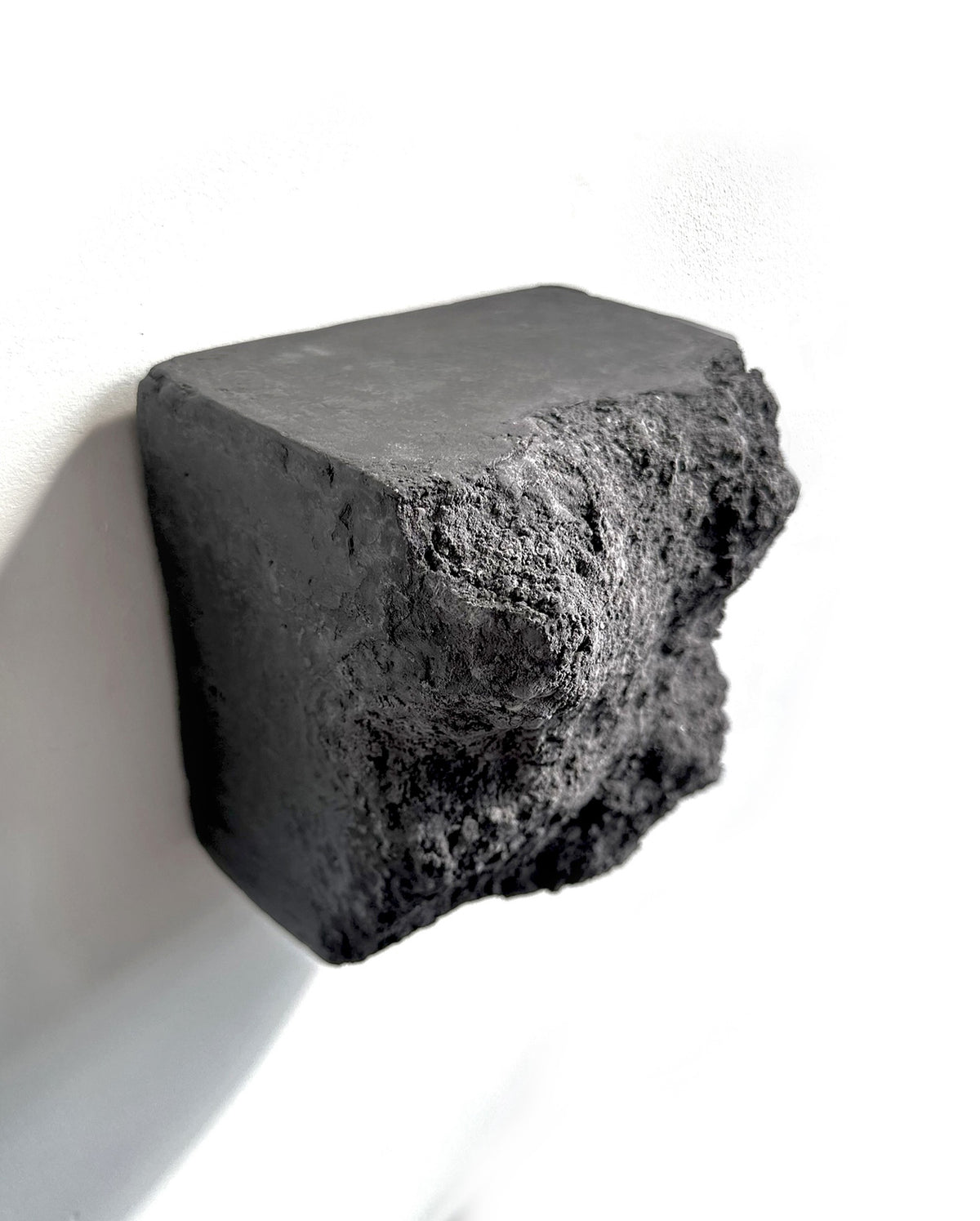 BROX — Charcoal Black, smooth top plane against rough broken face, raking light