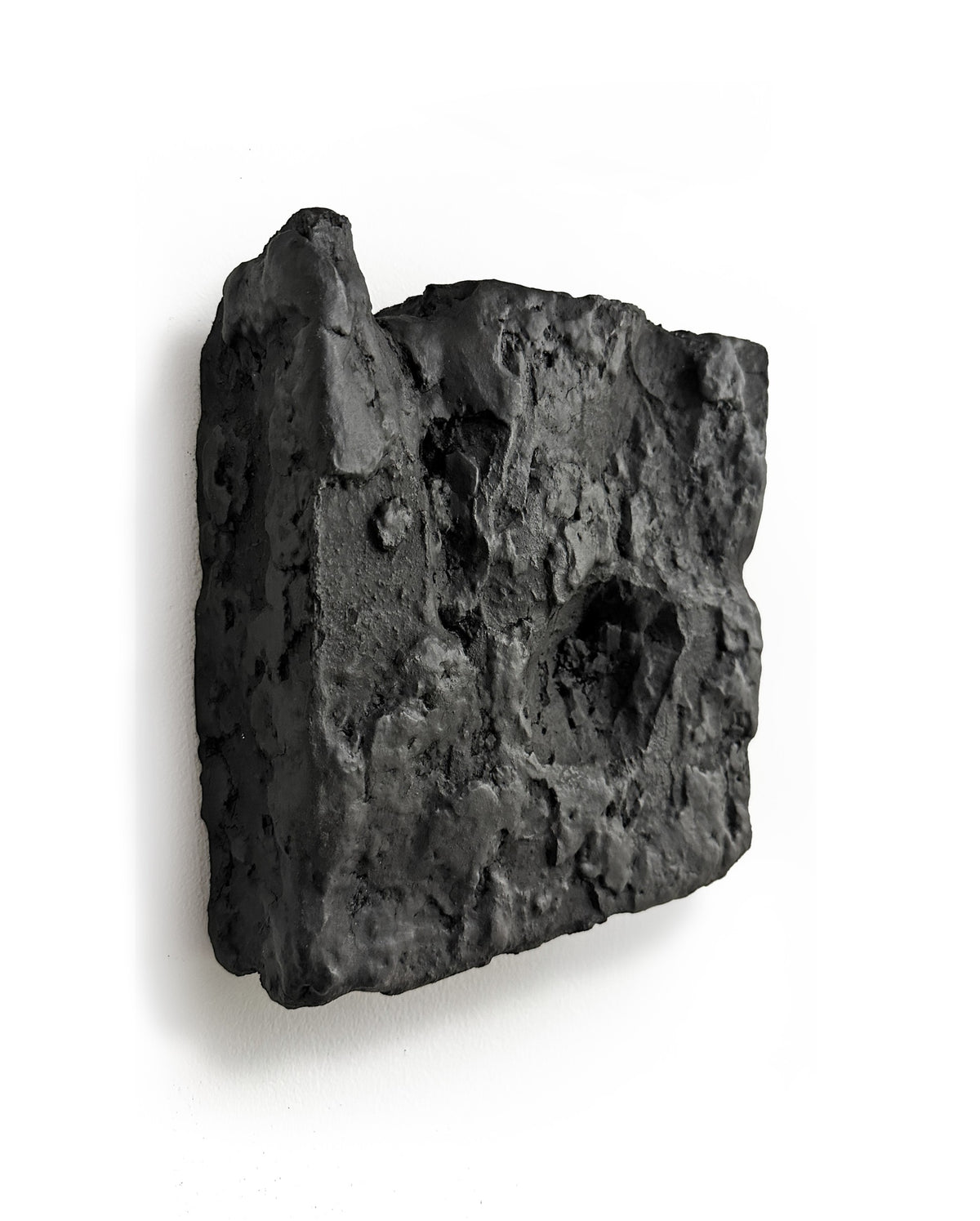 GAIA — Black Raw, side profile detail, depth and shadow, raw black plaster
