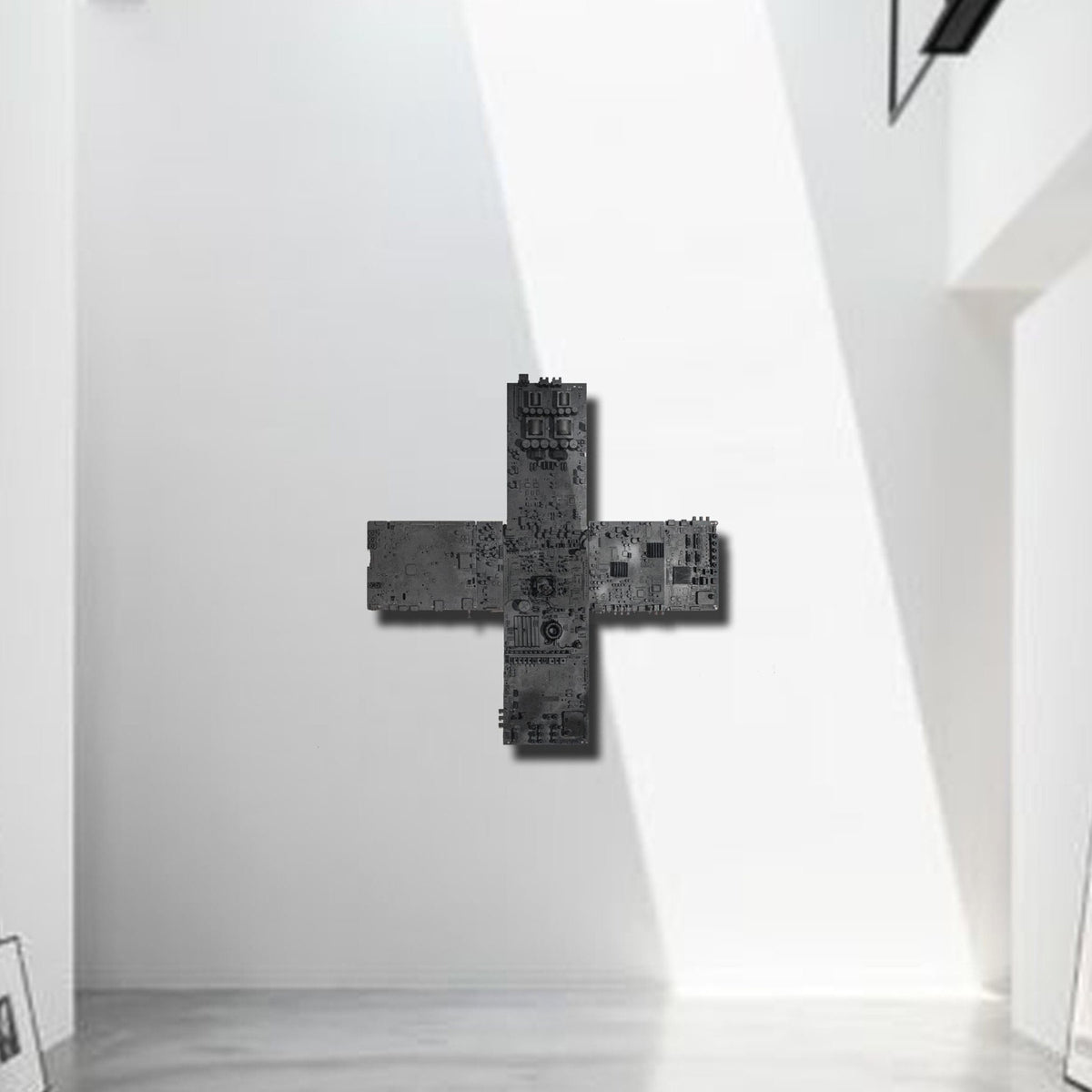 IF GOD IS IN ALL THINGS — black cross relief with circuit-board surface, white gallery wall in sunlight