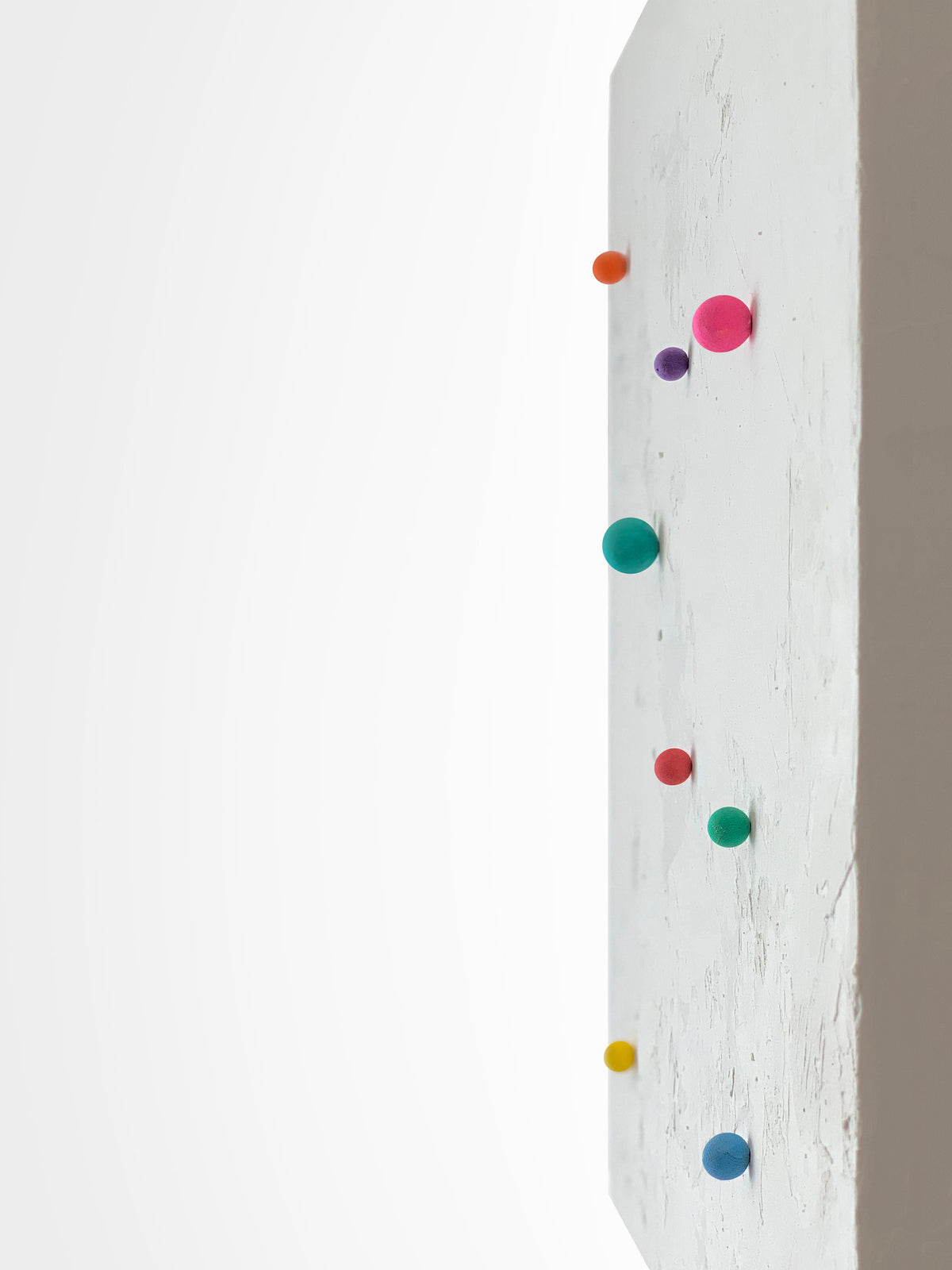 SHUN — White base, profile close-up of colored spheres along the white surface