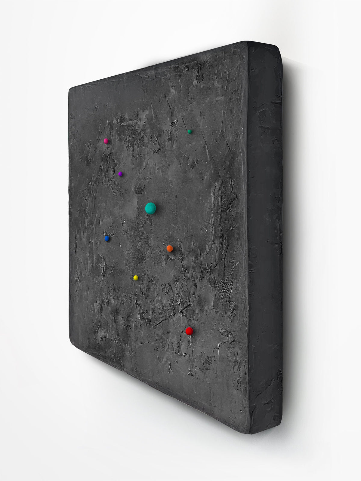 SHUN — Black base, three-quarter view, colored spheres on trowelled charcoal plaster
