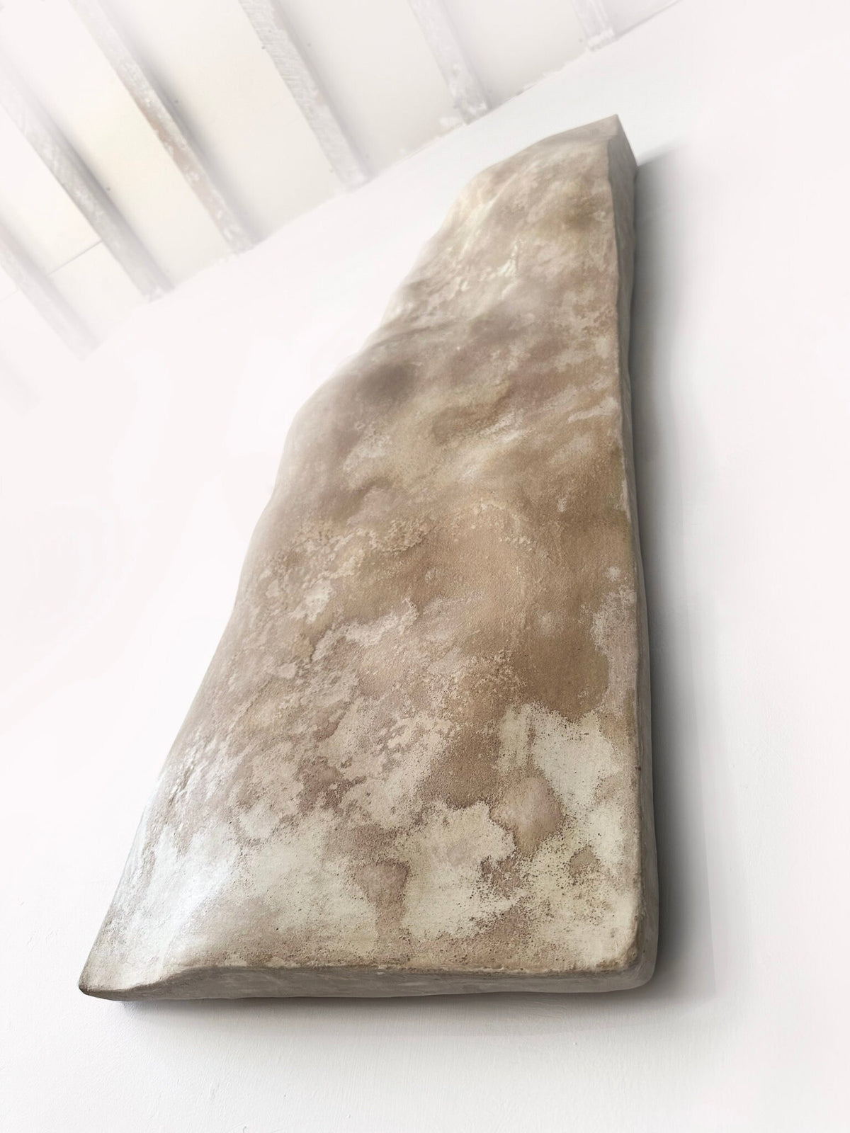 SANDSTONE — Taupe, angled view under skylight, warm textured surface