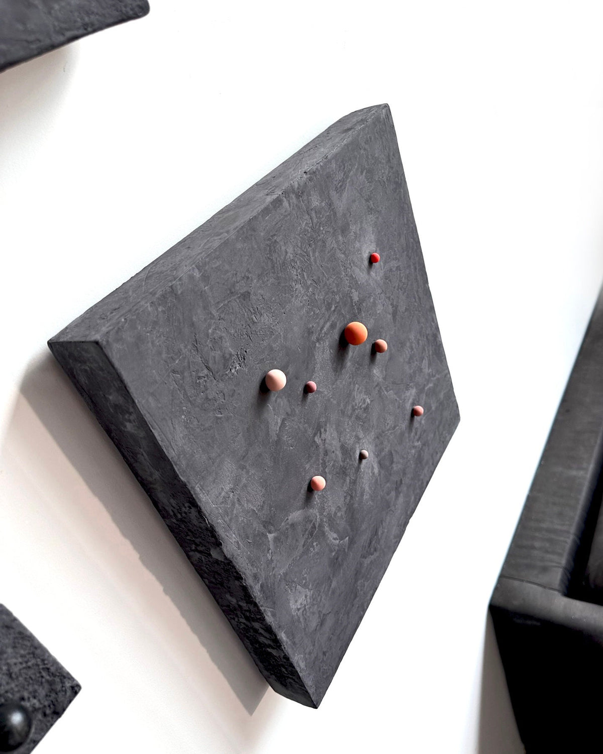 SHUN — Black base, angled view with terracotta dots, panel thickness visible
