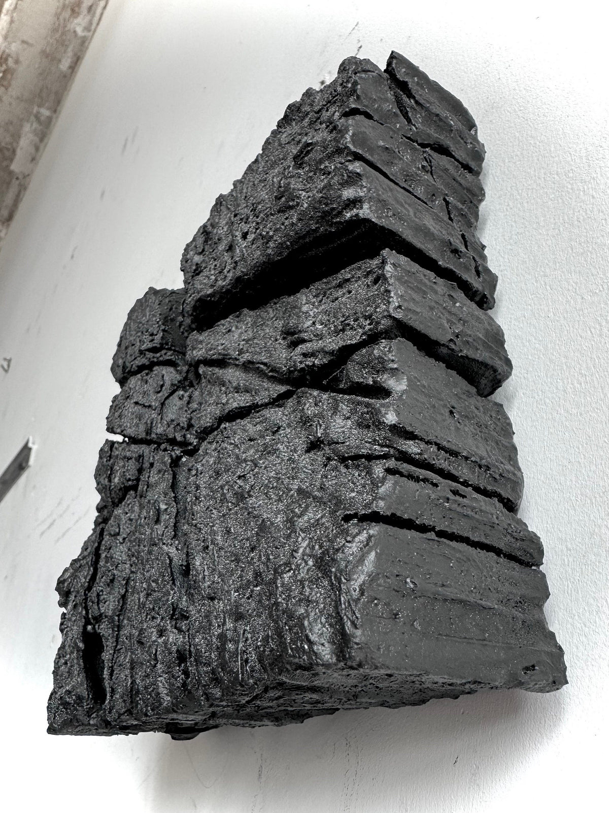 SAMURAI — Charcoal Black, profile view, layered edges projecting from the wall
