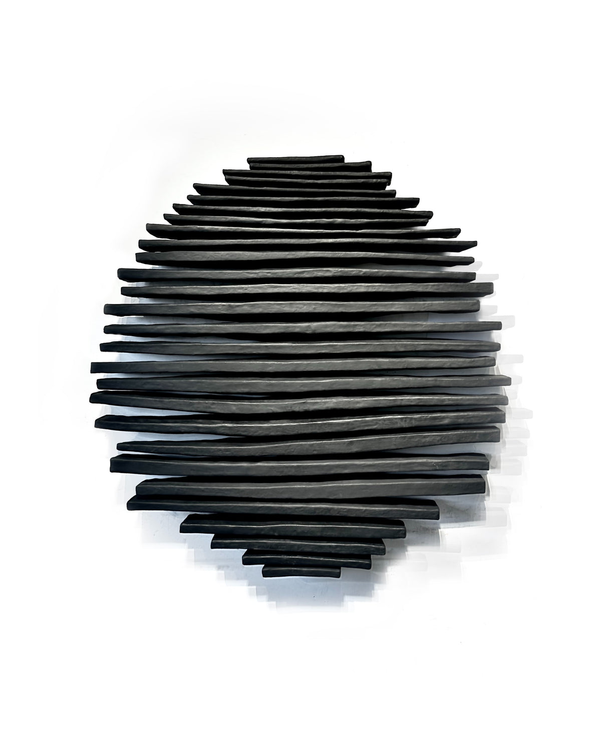 Black sculptural wall relief centered on a white gallery wall